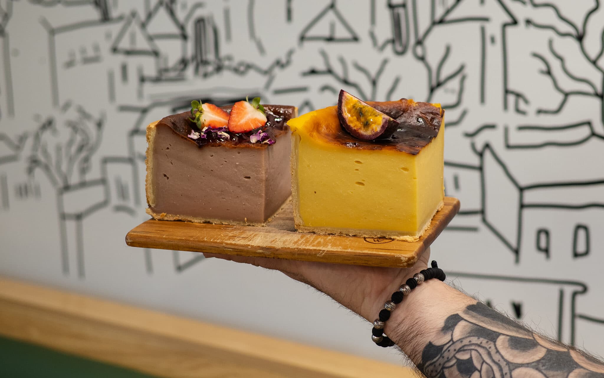 Two decorated Anaïs cake slices against the illustrated wall