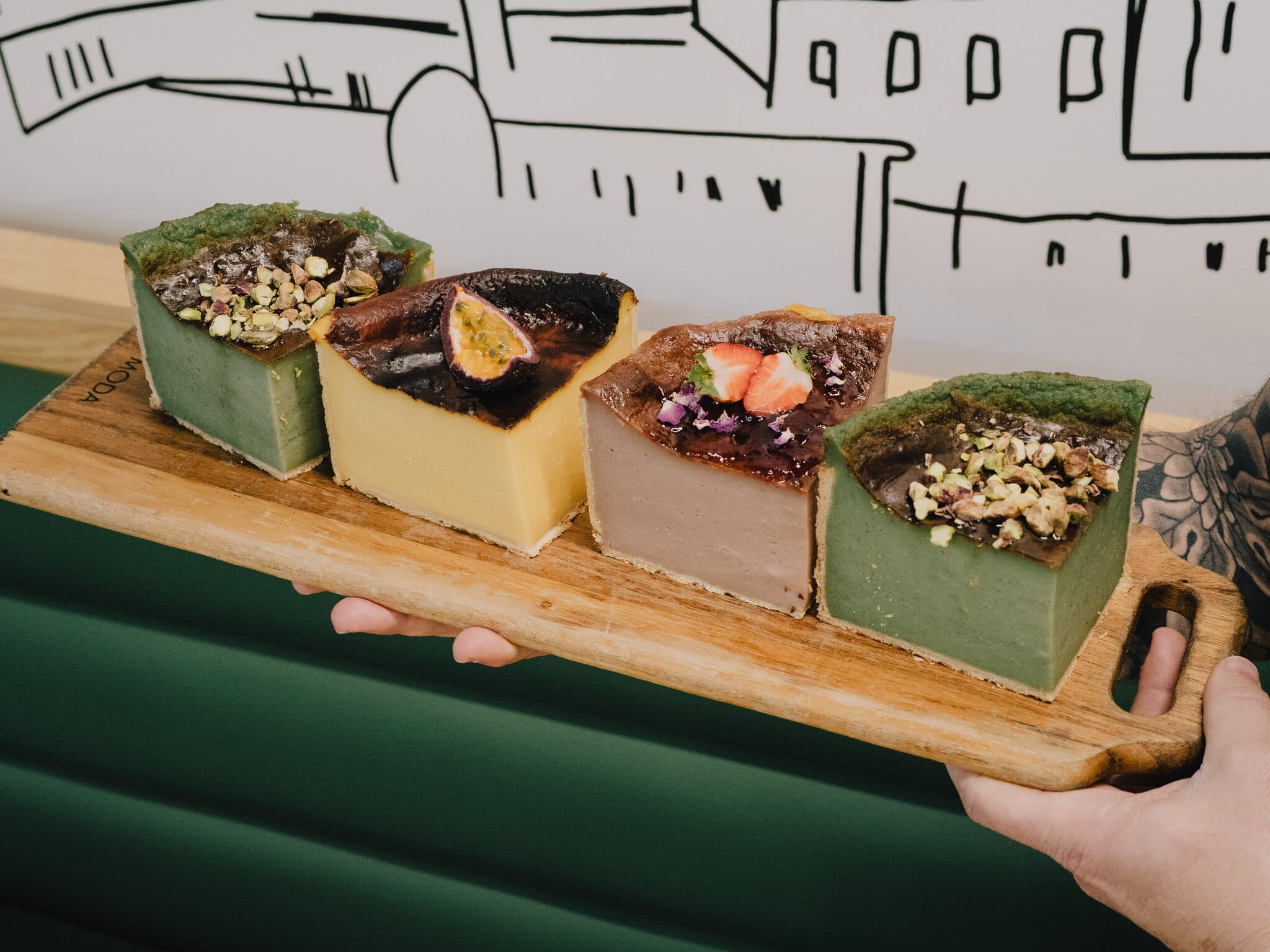 Four decorated Anaïs dessert squares on a serving board