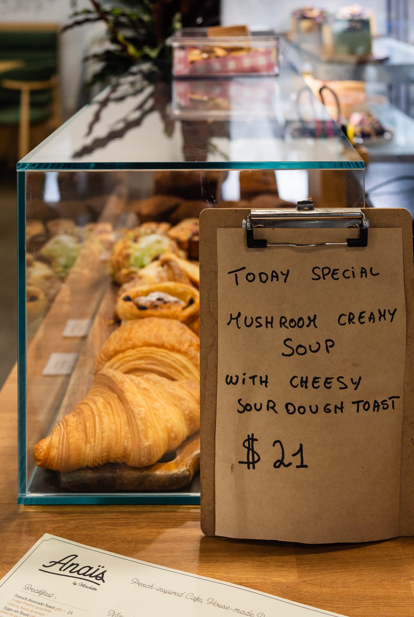 Croissants in the pastry case with the daily special sign